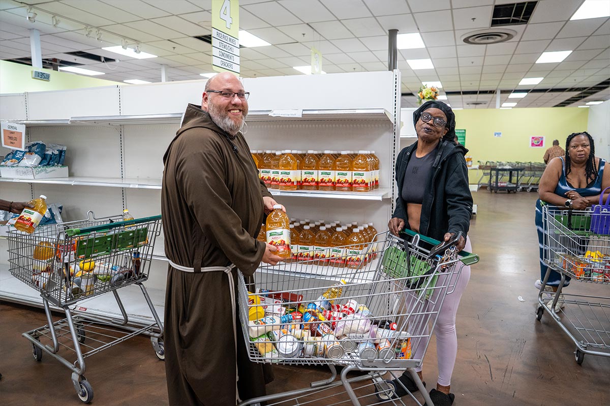 Br. Fred assists a guest at the Capuchin Services Center Shoppers' Choice Food Pantry.