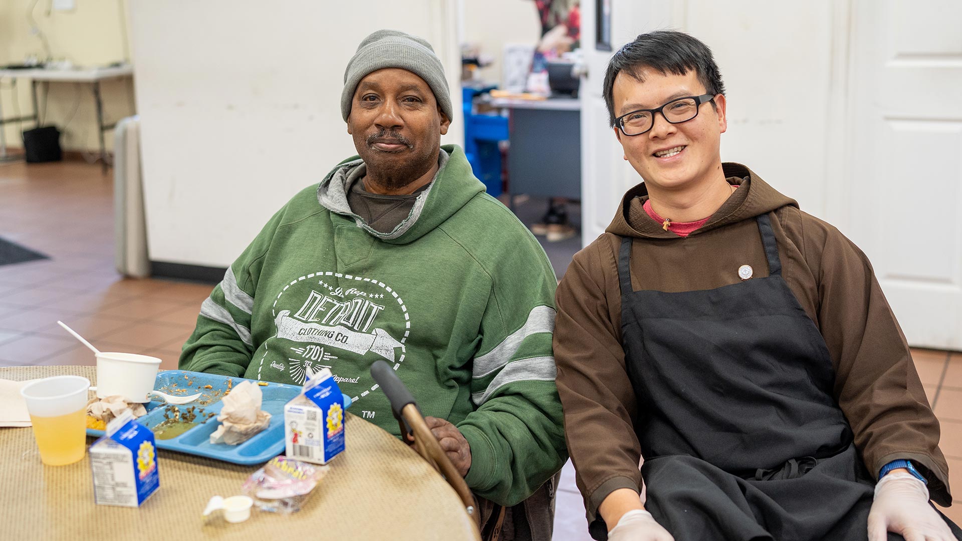 Br. Tien sits with a guest during lunch at the Meldrum Community Center.
